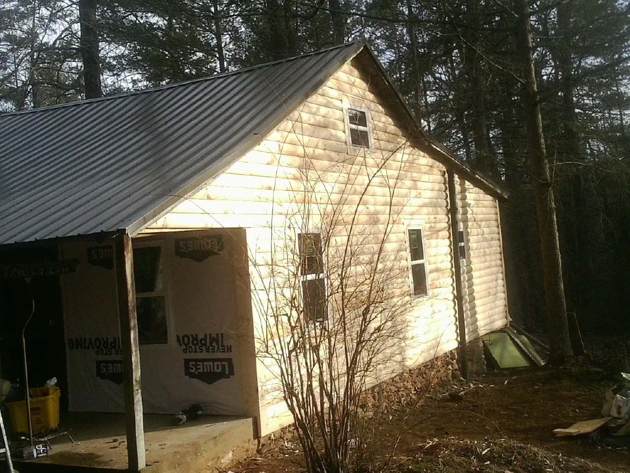 Log siding gable end under a dark metal roof edge in Rosalia