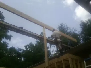 Carpenter setting a ridge beam over a new addition frame — Ice Dam Removal by Roofing Brothers in Rosalia