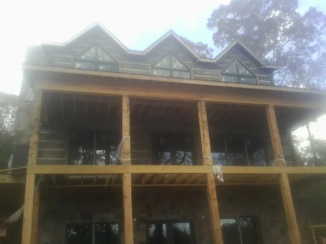 Dormers and porch framing on a large log home under construction — Roof Coating work by our crew in Rosalia