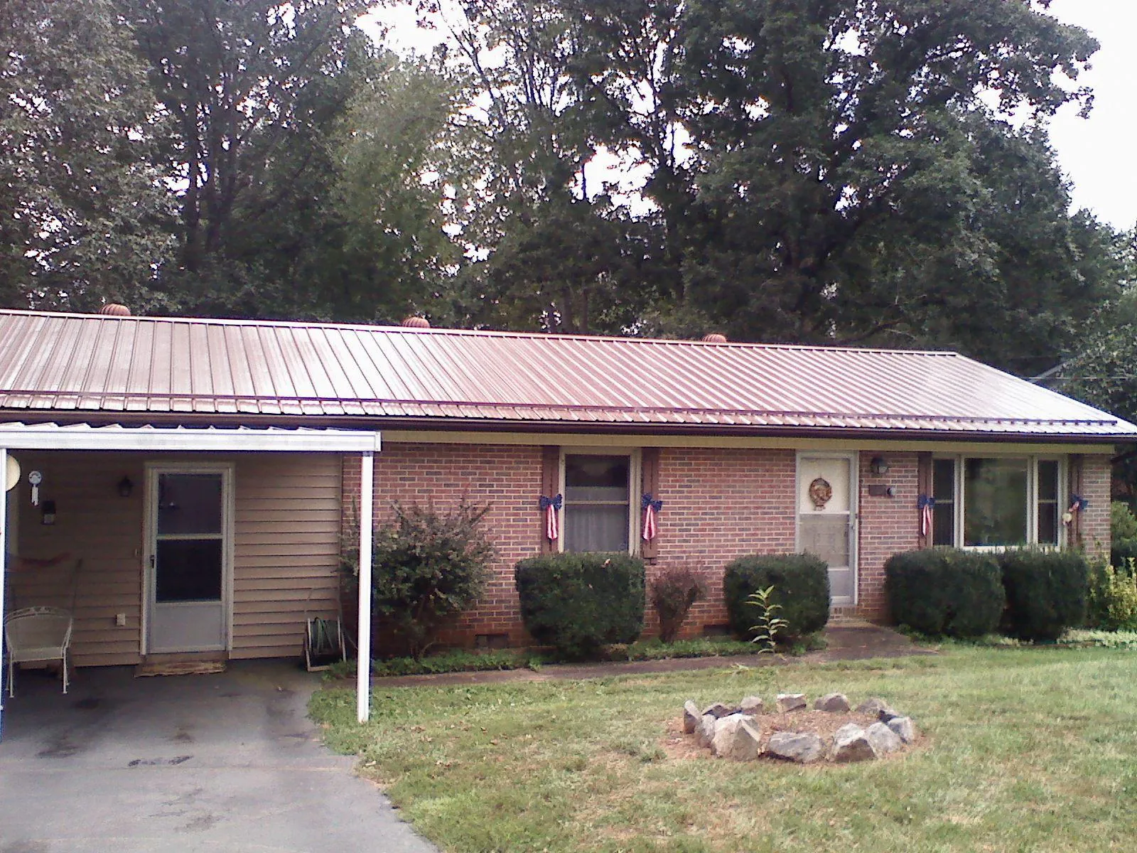 Bronze metal roof and carport on a brick ranch home — Roof Repair work by our crew in Rosalia